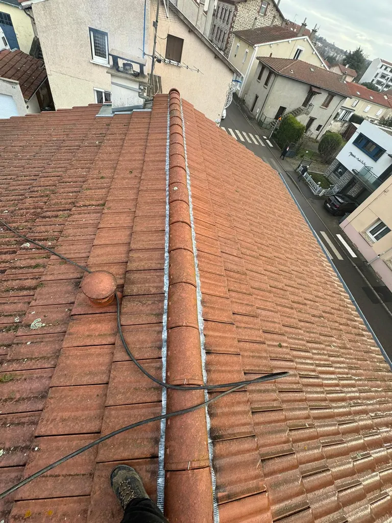 Faîtage d'une toiture en tuiles pendant l'intervention