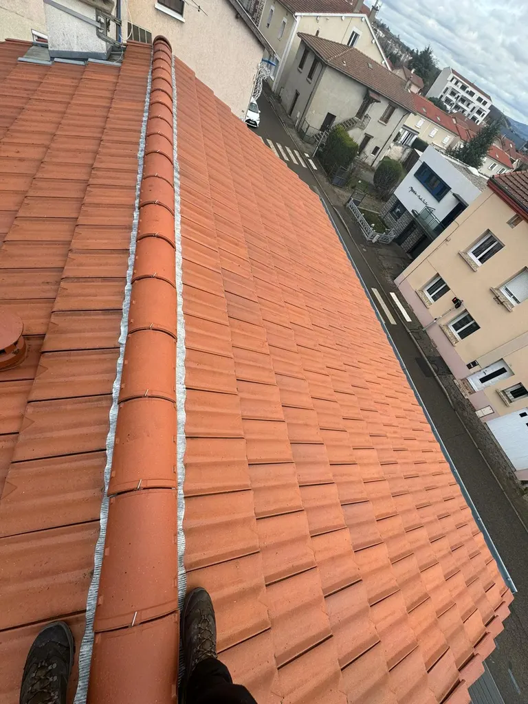 Toiture en tuiles rouges rénovée en zone urbaine