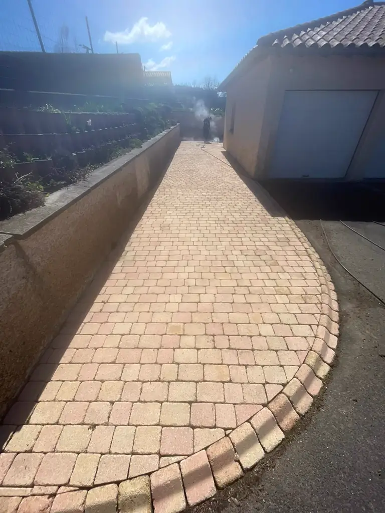 Allée pavée et murs extérieurs après intervention